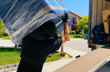 Ruff and Ready Moving team member loading a wrapped piece of furniture onto a moving truck for a cross-country move.