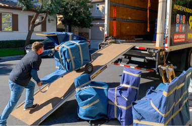 Ruff and Ready Moving team member pushing padded furniture up a ramp into a moving truck