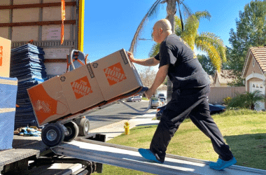 Ruff and Ready Moving team member pushing a dolly with boxes up the moving truck's ramp.